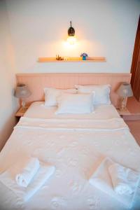 a white bed with two white pillows on it at Hazz Oda in Cesme