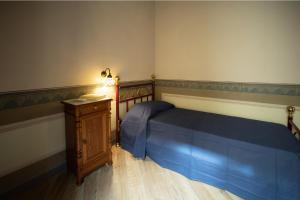 1 dormitorio con cama azul y tocador de madera en CEFAS Apartments, en Cefalú