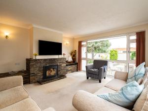 a living room with a fireplace and a flat screen tv at Longhouse Bungalow in Polzeath