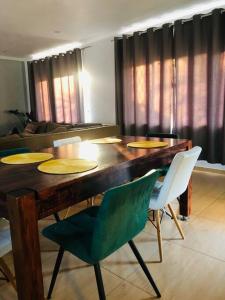 een eetkamer met een houten tafel en stoelen bij Modern Luxury 3 bedroom house in Durban