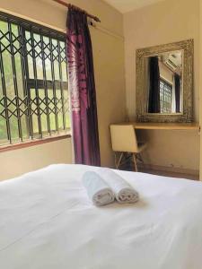 1 dormitorio con 1 cama y 2 toallas plegables. en Modern Luxury 3 bedroom house en Durban