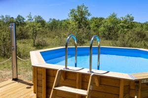 a wooden tub with a chair next to a swimming pool at La Grange - A Peaceful Place in the Forest in Concots
