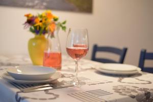 a glass of wine sitting on a table with plates at Ferienwohnung Glusavinahüsle in Vandans