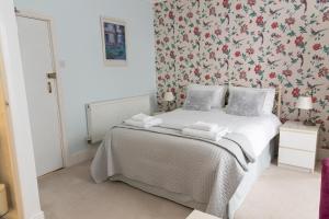 a bedroom with a bed with a floral wallpaper at Rosita Guest House in Weston-super-Mare