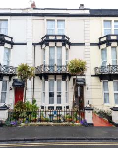 a white house with palm trees in front of it at Rosita Guest House in Weston-super-Mare