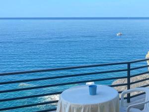 a table with a blue cup on top of the water at Hotel La Scogliera in Cavi di Lavagna