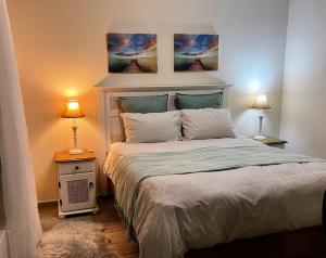 a bedroom with a large bed with two lamps at Silverdunes - Seaview in Bettyʼs Bay