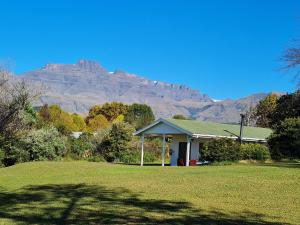 a house with a mountain in the background at Swallowfield Cottage in Champagne Valley