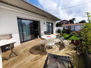 a patio with a white table and chairs on a deck at Maison Anglet, 4 pièces, 6 personnes - FR-1-239-758 in Anglet