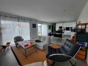 ein Wohnzimmer mit einem Sofa und einem Tisch in der Unterkunft Maison Anglet, 4 pièces, 6 personnes - FR-1-239-758 in Anglet