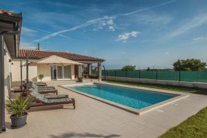 a swimming pool with two lounge chairs and a house at Villa Cristalines in Smoljanci