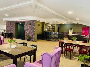 a restaurant with tables and purple chairs and a bar at Aura Boutique Hotel in Batumi