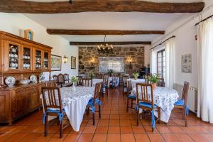 a dining room with tables and chairs and a stone wall at Quinta de Santo Antonio in Sá