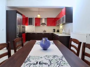 une cuisine avec une table et un vase bleu. dans l'établissement Gloria's House, à Kariá