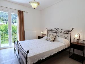 a bedroom with a bed and a large window at Gloria's House in Kariá