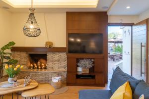 uma sala de estar com lareira e televisão em Green Acre Villa em Karteros