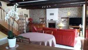 uma sala de estar com um sofá vermelho e uma mesa em Maison de Caractère Maryann56 em Noyal-Muzillac