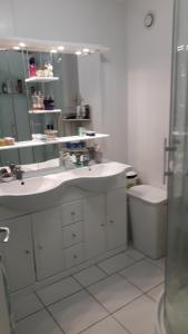 a bathroom with a sink and a mirror and a toilet at Maison de Caractère Maryann56 in Noyal-Muzillac