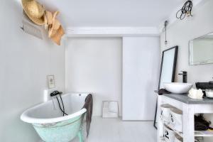 łazienka z wanną i umywalką w obiekcie Le Cocon en plein centre du village médiéval de Mougins vue mer w mieście Mougins
