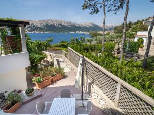 a balcony with a table and chairs and a view of the water at APARTMENT KORI in Baška