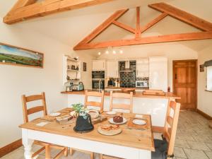 cocina y comedor con mesa de madera en Old Hall Byre en Leyburn