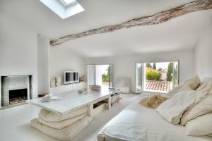 Biały salon ze stołem i kominkiem w obiekcie Le Cocon en plein centre du village médiéval de Mougins vue mer w mieście Mougins