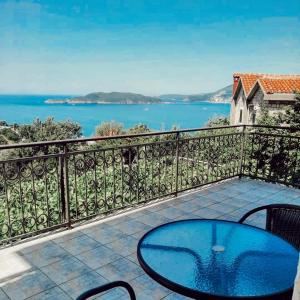 einen Balkon mit einem Tisch und Stühlen sowie Blick auf das Wasser in der Unterkunft Apartments Mitrović Podličak in Sveti Stefan