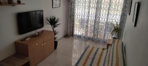 sala de estar con TV de pantalla plana y tocador en apartamento Anais en Salou