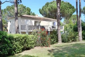 een wit huis met een balkon en bomen bij CASA RAMA ST Tropez in Saint-Tropez