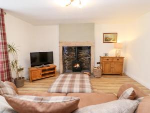 a living room with a couch and a fire place at Bracken Cottage in Bishop Auckland