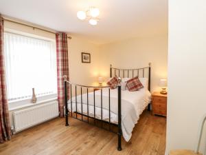 a bedroom with a bed and a window at Bracken Cottage in Bishop Auckland