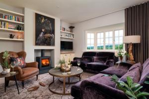 a living room with purple furniture and a fireplace at Higher Mapstone - A true retreat nestled in a private sanctuary on Dartmoor in Newton Abbot