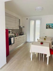 una cocina con una mesa blanca y una mesa blanca sidx sidx sidx en La Casa di Chiara, en Porto SantʼElpidio