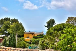 dom na środku ogrodu z drzewami w obiekcie Le Cocon en plein centre du village médiéval de Mougins vue mer w mieście Mougins