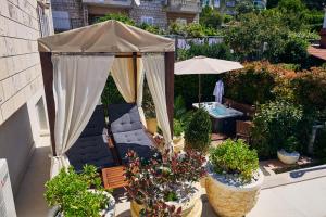 um gazebo com um guarda-chuva e algumas plantas em Rhea Silvia em Dubrovnik