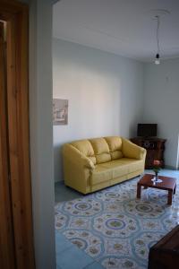 a living room with a yellow couch and a table at Guardia Piemontese: Ideale per Mare e Terme in Guardia Piemontese Terme