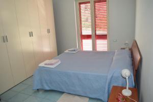 a bedroom with a blue bed and a window at Guardia Piemontese: Ideale per Mare e Terme in Guardia Piemontese Terme