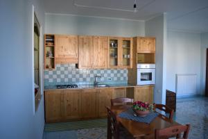 a kitchen with wooden cabinets and a table with chairs at Guardia Piemontese: Ideale per Mare e Terme in Guardia Piemontese Terme