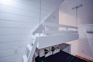 a white staircase in a room with white walls at "The Barndo" 4BR Luxury Cabin, Hot Tub, Fire Pit, Bunks, Arcades, Playhouse! in Broken Bow +46 photos