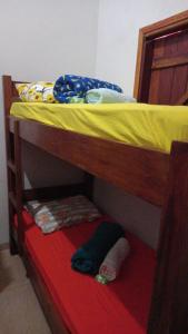 a bunk bed with a yellow sheet and a pillow on it at Guest House Recanto da Mata - BONITO - MS in Bonito
