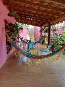 a hammock on a patio with chairs and a table at Guest House Recanto da Mata - BONITO - MS in Bonito