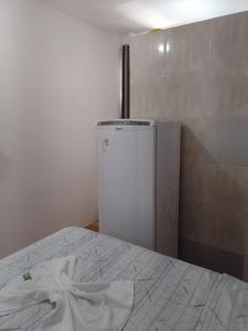 um frigorífico branco num quarto com uma cama em Pousada bandeirantes em Ilhéus