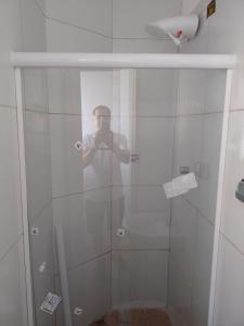un hombre tomando una foto de una ducha en Pousada bandeirantes, en Ilhéus