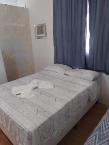 uma cama com uma camisa branca em cima em Pousada bandeirantes em Ilhéus