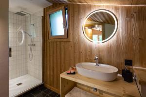 un bagno con un lavandino, una vasca e uno specchio di Chalet du Gouter - Chamonix All Year a Chamonix-Mont-Blanc Altre 21 foto