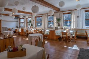 a restaurant with tables and chairs and windows at Hotel Restaurant Alatsee in Füssen +40 photos