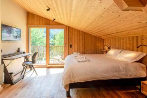 a bedroom with a bed and a desk and a window at Chalet du Gouter - Chamonix All Year in Chamonix