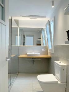 a bathroom with a sink and a toilet and a mirror at APARTAMENTOS LA PALMA FORNELLS in Fornells