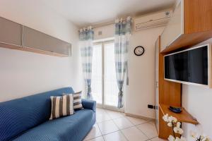 a living room with a blue couch and a tv at Condominium Volta Holiday Flat in Sanremo