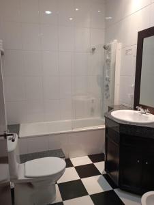 a bathroom with a toilet and a sink and a tub at Hotel / Restaurante LA PEPA in Avilés
